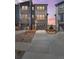 Modern townhome with a two-car garage, landscaping, and a well-lit driveway at sunset at 4355 Cyan Cir # E, Castle Rock, CO 80109