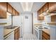 Efficient kitchen with white appliances and wood-look countertops at 14171 E Jewell Ave # 203, Aurora, CO 80012