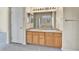 Bathroom featuring double sinks, linen cabinet, and a large well-lit mirror at 1034 Halfmoon Dr, Castle Rock, CO 80104
