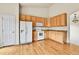 Kitchen featuring wood floors, wood cabinets and white appliances at 1034 Halfmoon Dr, Castle Rock, CO 80104