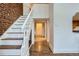 Hallway featuring wood floors, white walls, with staircase and view of the kitchen at 108 W Byers Pl # 106, Denver, CO 80223