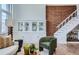 Living room showcasing exposed brick, built-in shelving, and stairs providing architectural interest and appeal at 108 W Byers Pl # 106, Denver, CO 80223