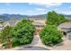 Scenic aerial view of home featuring mountain views and mature trees at 14682 W Amherst Pl, Lakewood, CO 80228