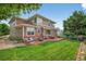 Spacious backyard features a red concrete patio with seating area, lawn and garden at 14682 W Amherst Pl, Lakewood, CO 80228