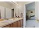 Well-lit bathroom features a spacious vanity and a doorway view into the adjacent bedroom at 14682 W Amherst Pl, Lakewood, CO 80228