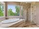 Elegant bathroom with a soaking tub, walk-in shower, and scenic views from the large windows at 14682 W Amherst Pl, Lakewood, CO 80228