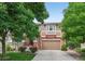 Inviting exterior showcasing brick accents, siding, and a cozy porch, framed by lush greenery at 14682 W Amherst Pl, Lakewood, CO 80228