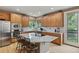 Spacious kitchen with wood cabinets, granite countertops, stainless appliances, and a center island with seating at 14682 W Amherst Pl, Lakewood, CO 80228