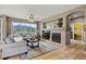 Bright living room featuring a cozy fireplace, large windows with scenic views, and hardwood floors at 14682 W Amherst Pl, Lakewood, CO 80228