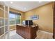 Bright office space with a large wooden desk, natural light, and views of the lush outdoors at 14682 W Amherst Pl, Lakewood, CO 80228