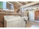 Unfinished basement featuring concrete floors, exposed brick walls, utility sink and washer/dryer at 22 E Bayaud Ave, Denver, CO 80209