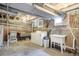 Unfinished basement with washer, dryer, utility sink and exposed brick walls and concrete floor at 22 E Bayaud Ave, Denver, CO 80209
