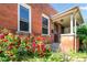 Charming brick home featuring a cozy covered porch and vibrant landscaping, including colorful roses at 22 E Bayaud Ave, Denver, CO 80209