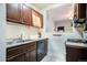 Cozy kitchen with dark wood cabinets, stainless sink, and a view to the entry room at 22 E Bayaud Ave, Denver, CO 80209