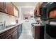 Efficient kitchen featuring dark wood cabinets, modern appliances, and a view into the adjacent living area at 22 E Bayaud Ave, Denver, CO 80209
