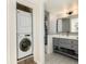 Modern bathroom featuring stylish vanity and storage, as well as stacked washer and dryer at 7665 E Eastman Ave # 107B, Denver, CO 80231