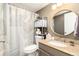 Bathroom features shower, storage shelving, granite vanity and round mirror at 7665 E Eastman Ave # 107B, Denver, CO 80231