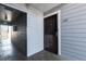 Exterior view of unit 107 featuring a black metal door and gray wood paneling at 7665 E Eastman Ave # 107B, Denver, CO 80231