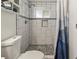 Bathroom featuring a tiled shower with a built-in niche and bench and a dark stone floor at 8410 Gray St, Arvada, CO 80003