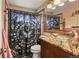 Bathroom featuring a glass vessel sink, decorative mirror, and decorative shower curtain at 8410 Gray St, Arvada, CO 80003