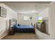 Finished bedroom with an iron frame bed, dresser, and window allowing for natural light at 8410 Gray St, Arvada, CO 80003