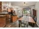 Cozy dining area adjacent to the kitchen, featuring dark wood floors and backyard views at 8410 Gray St, Arvada, CO 80003