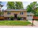 Charming two-story home with a well-manicured lawn, brick accents, and an attached garage at 8410 Gray St, Arvada, CO 80003