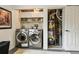 Laundry room featuring a front load washer and dryer, cabinetry, and water heater at 8410 Gray St, Arvada, CO 80003