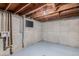Unfinished basement featuring concrete walls, wooden beams, and painted floor at 867 S Grape St, Denver, CO 80246