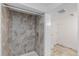 Shower with tile surround, white trim and tile flooring leading to toilet at 867 S Grape St, Denver, CO 80246