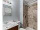 Tiled shower, wood vanity, and neutral walls create a soothing bathroom space at 867 S Grape St, Denver, CO 80246