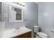 Neat bathroom with white vanity, modern sink, matching toilet and neutral-toned tile flooring at 867 S Grape St, Denver, CO 80246