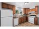 Well-lit kitchen featuring wooden cabinets, stainless steel sink, and modern white appliances at 867 S Grape St, Denver, CO 80246