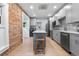 Modern kitchen with gray cabinets, stainless steel appliances, and exposed brick detail at 2737 N Marion St, Denver, CO 80205