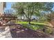 Expansive backyard with a lush lawn, mature tree, deck, and playground, perfect for outdoor enjoyment at 9998 W 70Th Pl, Arvada, CO 80004