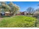 Spacious backyard with mature trees, a deck, and a lawn, ideal for outdoor activities and relaxation at 9998 W 70Th Pl, Arvada, CO 80004