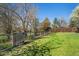Fenced backyard with a green lawn and mature trees, offering privacy and a peaceful outdoor space at 9998 W 70Th Pl, Arvada, CO 80004