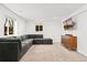 Basement rec room with large sectional couch, TV and cabinet, and cozy carpet at 9998 W 70Th Pl, Arvada, CO 80004