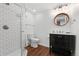 Bathroom featuring a shower, toilet, and vanity with round mirror and modern lighting at 9998 W 70Th Pl, Arvada, CO 80004