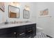 Bathroom with double vanity, black cabinets, and granite countertops at 9998 W 70Th Pl, Arvada, CO 80004