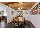 Dining room has a wood plank ceiling, black rug, and view to the kitchen at 9998 W 70Th Pl, Arvada, CO 80004