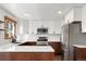 Bright kitchen with white cabinets, stainless steel appliances, and quartz countertops at 9998 W 70Th Pl, Arvada, CO 80004