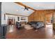 Spacious living room with wood-paneled accent wall, vaulted ceilings, and hardwood floors at 9998 W 70Th Pl, Arvada, CO 80004