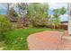 Expansive backyard features well-maintained lawn, mature trees, and brick patio area at 1842 Reliance Cir, Superior, CO 80027