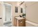 This half bathroom has a wood vanity, a marble countertop, a modern faucet, and is well lit at 1842 Reliance Cir, Superior, CO 80027