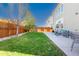 Well-maintained backyard with a lush lawn, privacy fence, and a cozy patio seating area at 381 Rainbow Ln, Lafayette, CO 80026