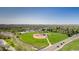 Aerial view of a baseball field with lush green grass, surrounded by trees and a neighborhood at 381 Rainbow Ln, Lafayette, CO 80026