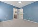 Comfortable bedroom with blue walls, carpet, and doorways to the bathroom and hallway at 381 Rainbow Ln, Lafayette, CO 80026
