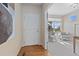 Inviting entryway with hardwood floors and modern artwork, leading to a bright and airy sitting room with large windows at 381 Rainbow Ln, Lafayette, CO 80026