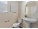 Cozy powder room featuring a pedestal sink, round mirror, and neutral color scheme, offering a clean and simple design at 381 Rainbow Ln, Lafayette, CO 80026